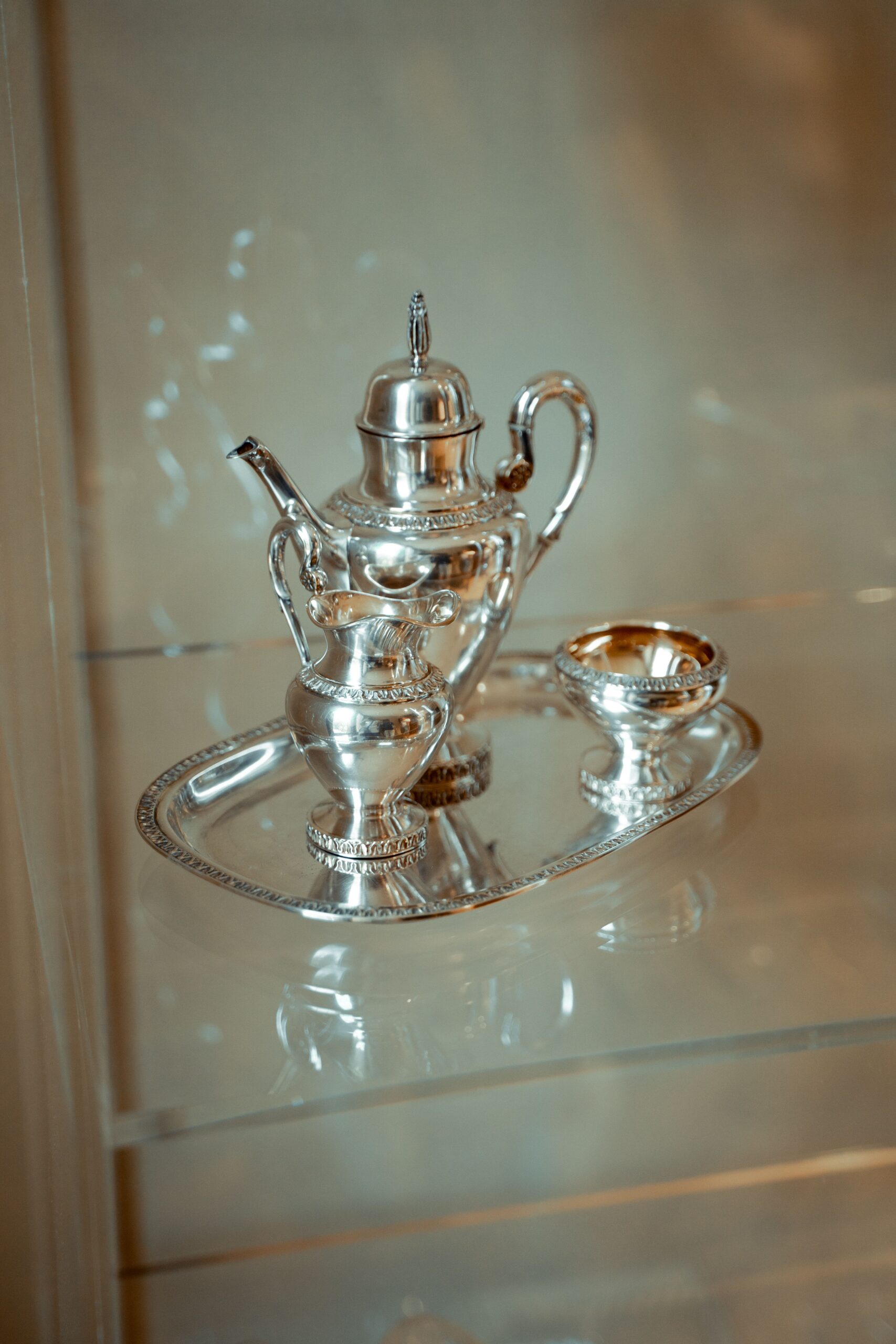 Luxurious silver teapot set displayed elegantly in a glass cabinet.